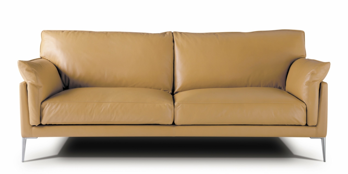 Un canapé en cuir beige de haute qualité avec des pieds en métal se détache élégamment sur le fond blanc, rappelant une pièce d'exposition sophistiquée. Canape Paris by Atelier Bis