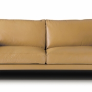 Un canapé en cuir beige de haute qualité avec des pieds en métal se détache élégamment sur le fond blanc, rappelant une pièce d'exposition sophistiquée. Canape Paris by Atelier Bis