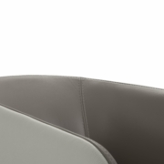 Gros plan sur le bord d'une chaise moderne avec une finition en cuir lisse gris clair, rappelant l'élégance que l'on retrouve dans un showroom parisien. Canape Paris by Atelier Bis