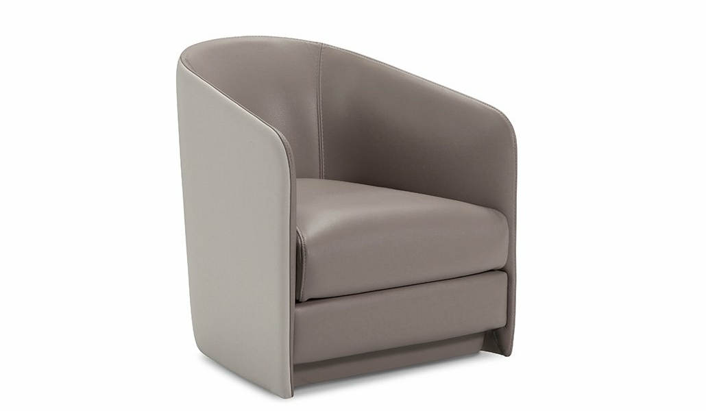 Une chaise pivotante grise moderne avec un dossier lisse et incurvé et un revêtement en cuir orne le showroom parisien, sur fond blanc immaculé. Canape Paris by Atelier Bis