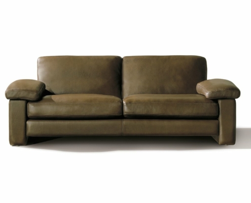 Canapé en cuir marron avec coussins épais et larges accoudoirs, élégamment mis en scène dans un showroom minimaliste sur un fond blanc uni. Canape Paris by Atelier Bis