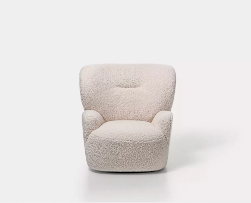 Un fauteuil moelleux, blanc et texturé, au design arrondi, dégage un air d'élégance parisienne, positionné sur un fond blanc uni. Canape Paris by Atelier Bis