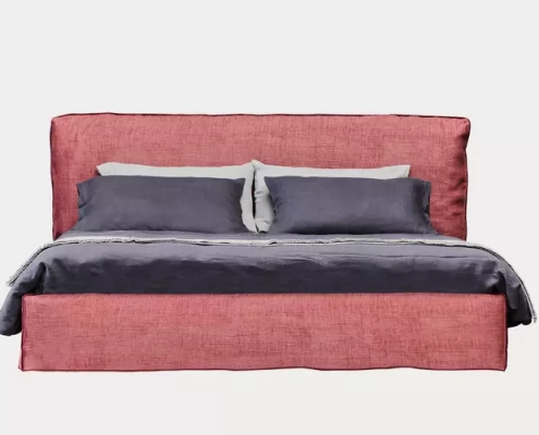 Découvrez un chef-d'œuvre de salle d'exposition : un lit doté d'une tête de lit capitonnée rose, complétée par une literie grise et deux oreillers moelleux, le tout sur un fond clair. Canape Paris by Atelier Bis