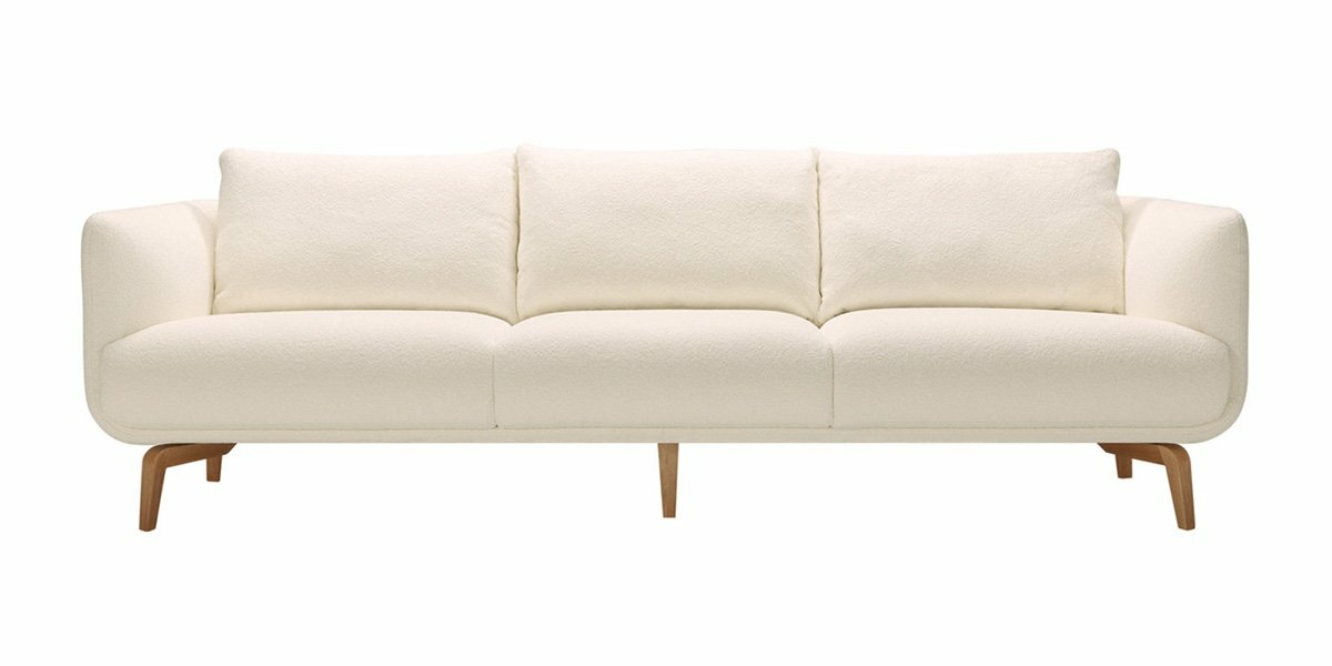 Un canapé trois places blanc et moderne avec des pieds en bois capture l'essence de l'élégance parisienne, sur un fond blanc immaculé. Canape Paris by Atelier Bis