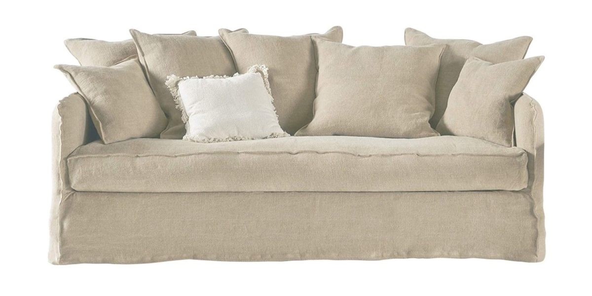 Un canapé beige orné de plusieurs coussins assortis et d'un coussin central à franges blanches respire la qualité parisienne. Canape Paris by Atelier Bis