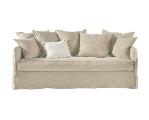 Un canapé beige avec sept coussins assortis et un coussin d'appoint blanc, parfait pour un showroom d'inspiration parisienne. Canape Paris by Atelier Bis