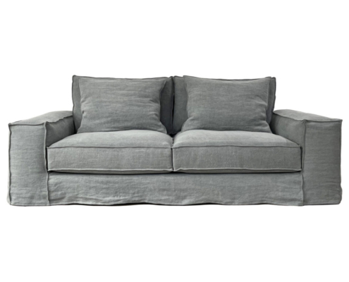 Canapé deux places gris avec assises et dossiers rembourrés, doté de larges accoudoirs et d'un design décontracté. Découvrez la qualité d'un showroom qui apporte une touche d'élégance parisienne à tout espace de vie. Canape Paris by Atelier Bis