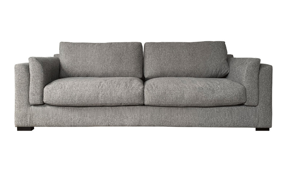 Canapé rembourré gris avec coussins épais et accoudoirs, reflétant la qualité, sur un fond blanc uni. Canape Paris by Atelier Bis