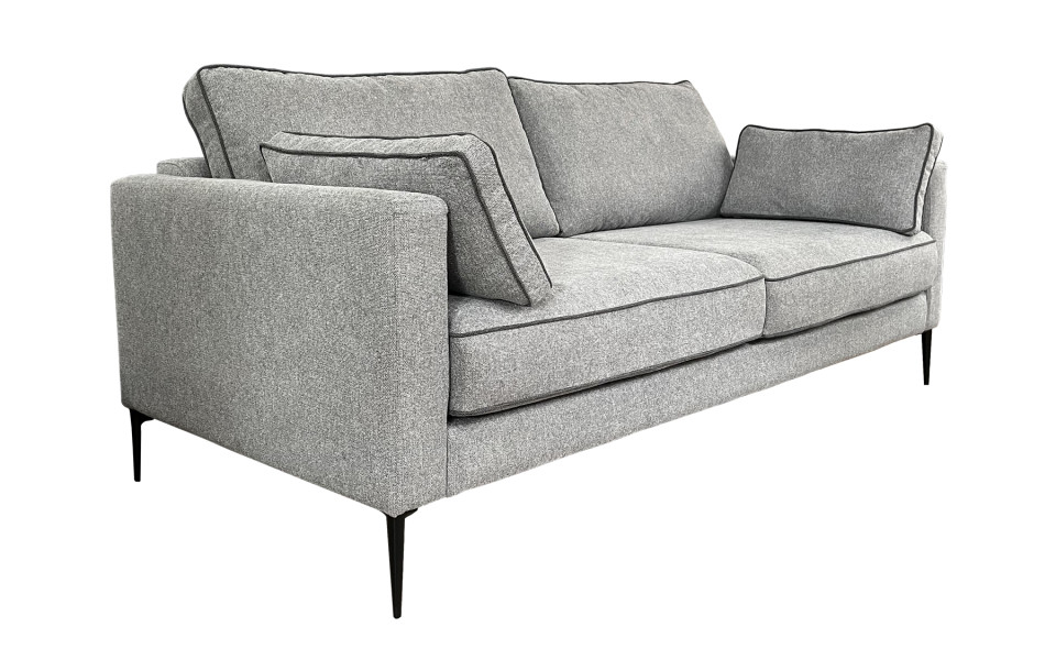 canape-4-places-peter-200-cm-1 Un canapé gris moderne avec passepoil noir et coussins de dossier inclinés sur des pieds noirs minces, présenté sur un fond blanc. Canape Paris by Atelier Bis