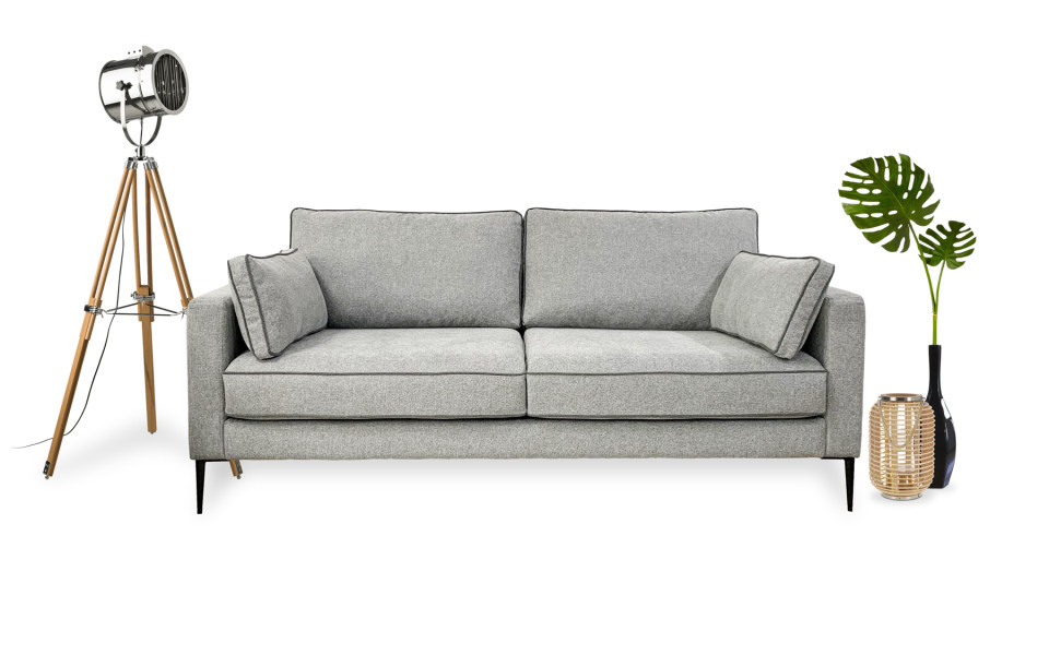 canape-4-places-peter-200-cm-2 Canapé gris avec deux coussins, une lampe trépied à gauche et deux vases avec des feuilles à droite, dégageant une touche parisienne chic. Canape Paris by Atelier Bis