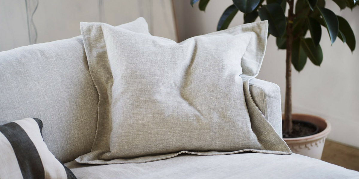 3_BRITT_interior_set2_caleido_stampato_1_natur_6 Une décoration chic avec un canapé en velours vert émeraude, des coussins en soie et un lustre élégant.