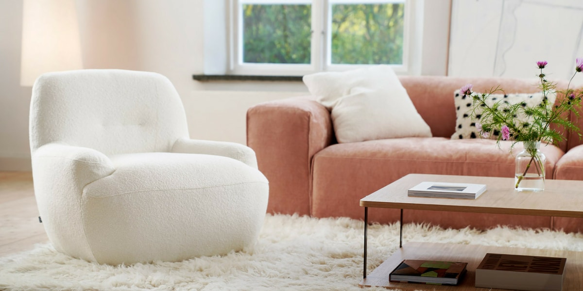 6_UMA_interior_armchair_willow_1_off_white_2 Fauteuil Uma en velours blanc avec un tapis marron et des accents jaunes Le fauteuil en velours blanc repose sur un tapis marron, avec des accents jaunes dispersés dans la pièce pour une touche de gaieté.