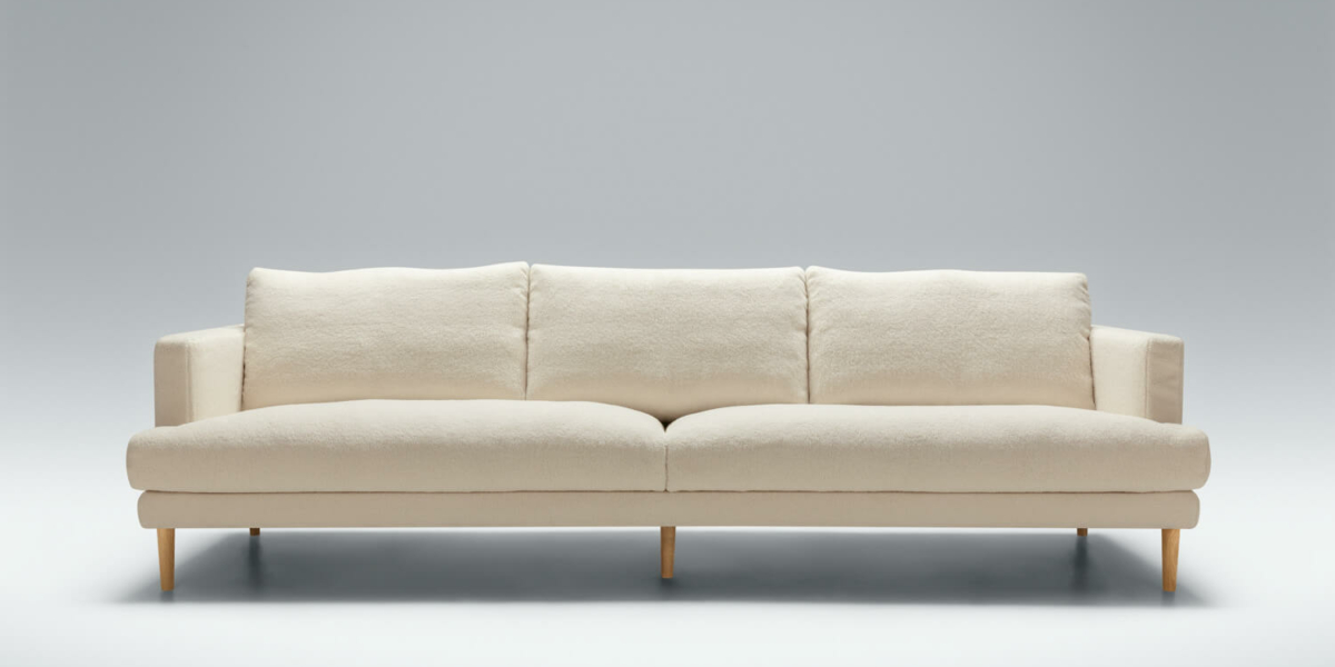 61cedc19b2978c5c125e9a77_9_BRITT_studio_4seater_poodle_1_cream_1 Un salon boho avec un canapé en lin, des tapis ethniques et des paniers en osier.