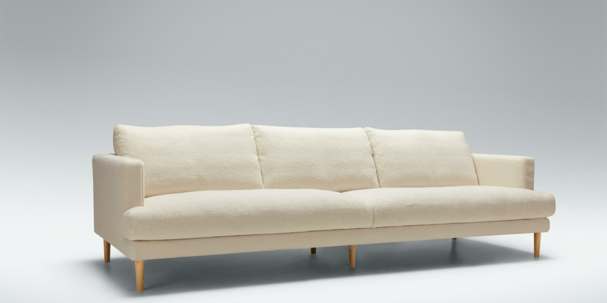 61cedc1b57f552b6b5a288ea_10_BRITT_studio_4seater_poodle_1_cream_2 Une décoration minimaliste avec un canapé blanc, un tapis gris clair et des meubles en bois clair.