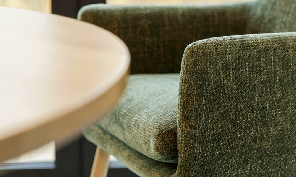 61ceddb7fb6a1068edfb7adf_MOA_bistro_chair_bloom_6_green_4 Fauteuil Moa Bistro en cuir brun dans un salon avec des murs en briques apparentes Le fauteuil en cuir brun se trouve dans un salon industriel avec des murs en briques apparentes, créant une ambiance chaleureuse et rustique.