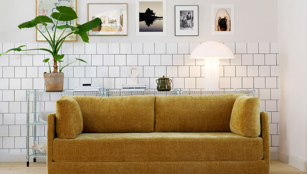 Canapé convertible en lit Stina en tissu marron clair avec des oreillers assortis Le canapé Stina en tissu marron clair est accompagné d'oreillers assortis, créant une ambiance douce et accueillante dans le salon.