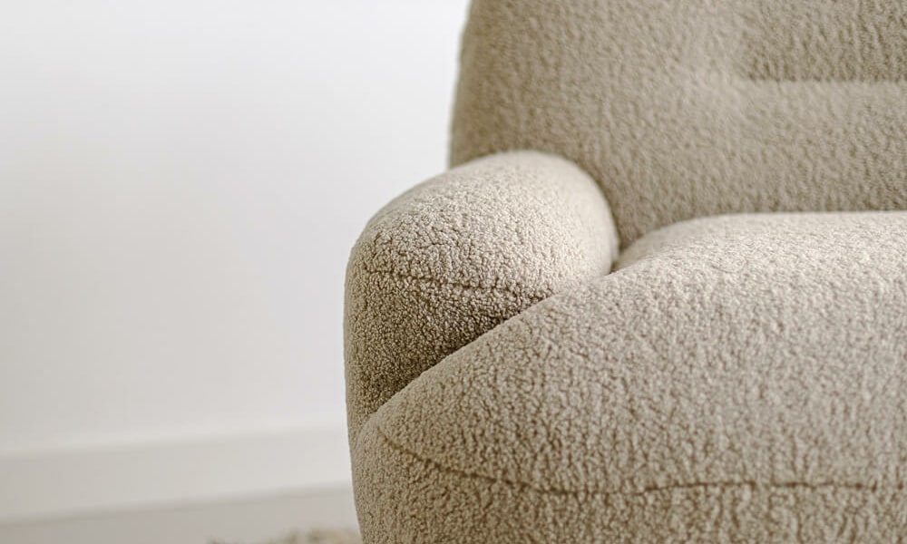 61cedeac7e4e910566190177_4_UMA_interior_armchair_poodle_1_cream_4 Fauteuil Uma en cuir marron avec un tapis jaune à motifs géométriques Le fauteuil en cuir marron se trouve sur un tapis jaune à motifs géométriques, créant un contraste vibrant et moderne.Le fauteuil en tissu jaune moutarde est agrémenté de coussins marron, apportant une touche chaleureuse et accueillante au salon.