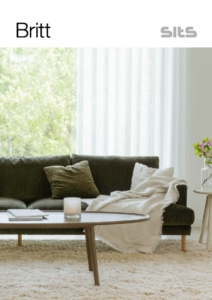 632814a02b475a0c45b1a1ad-britt-pdf-728x1030 Un salon cosy à Paris avec un canapé vert foncé orné d'une couverture et de coussins, complété par une table basse en bois et un tapis moelleux. Canape Paris by Atelier Bis