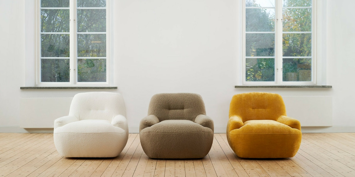 7_UMA_interior_armchair_willow_1_off_white_poodle_3_beige_wildflower_5_warm_-yellow_1 Fauteuil Uma en tissu marron clair avec des coussins blancs et jaunes Le fauteuil en tissu marron clair est orné de coussins blancs et jaunes, créant une atmosphère lumineuse et apaisante.