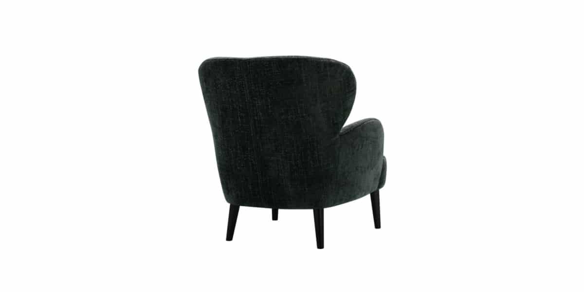 Fauteuil Ross en noir avec un plaid en laine grise Accompagné d'un plaid en laine grise, le fauteuil Ross en noir offre une atmosphère chaleureuse et confortable, parfaite pour se détendre.