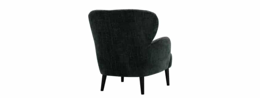 Fauteuil Ross en noir avec un plaid en laine grise Accompagné d'un plaid en laine grise, le fauteuil Ross en noir offre une atmosphère chaleureuse et confortable, parfaite pour se détendre.