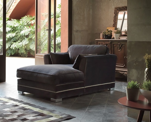 Canapé luxueux dans une pièce cosy avec plantes, grandes fenêtres et armoire décorative, rappelant un appartement parisien chic. Canape Paris by Atelier Bis