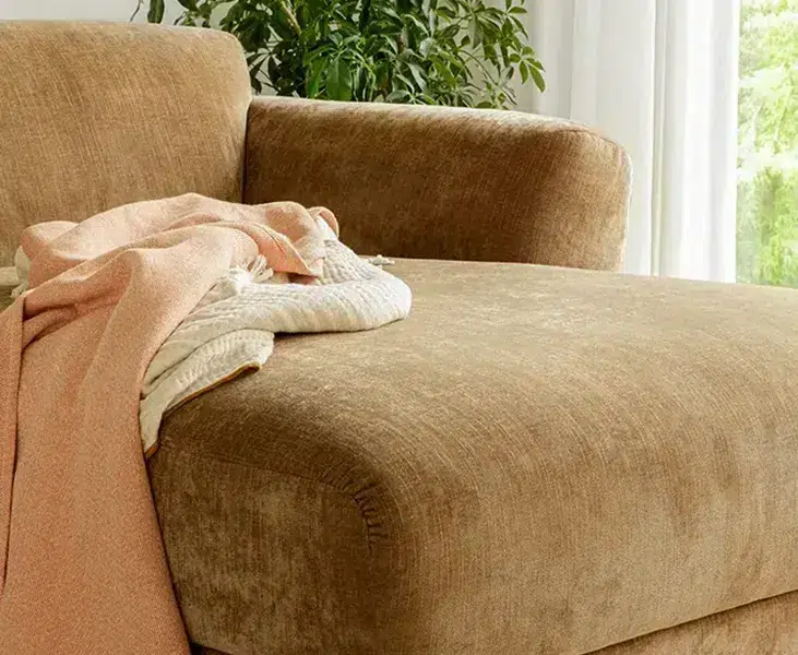 ASTA_SITS_canape-paris_04 Une photo du canapé Asta marron dans un salon de style scandinave avec des accents de couleur pastel et des meubles en bois clair pour une ambiance douce et épurée.