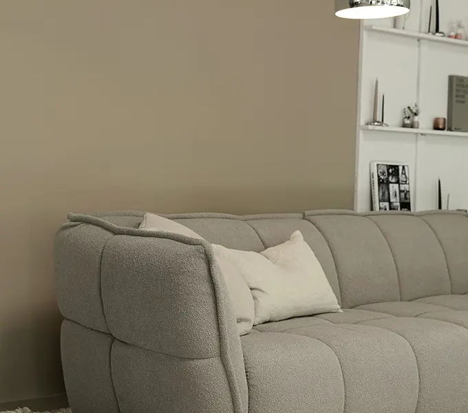 CLYDE_SITS_canape-paris_02 Une photo du canapé Clyde gris dans un cadre minimaliste avec des plantes vertes pour une touche de fraîcheur naturelle.