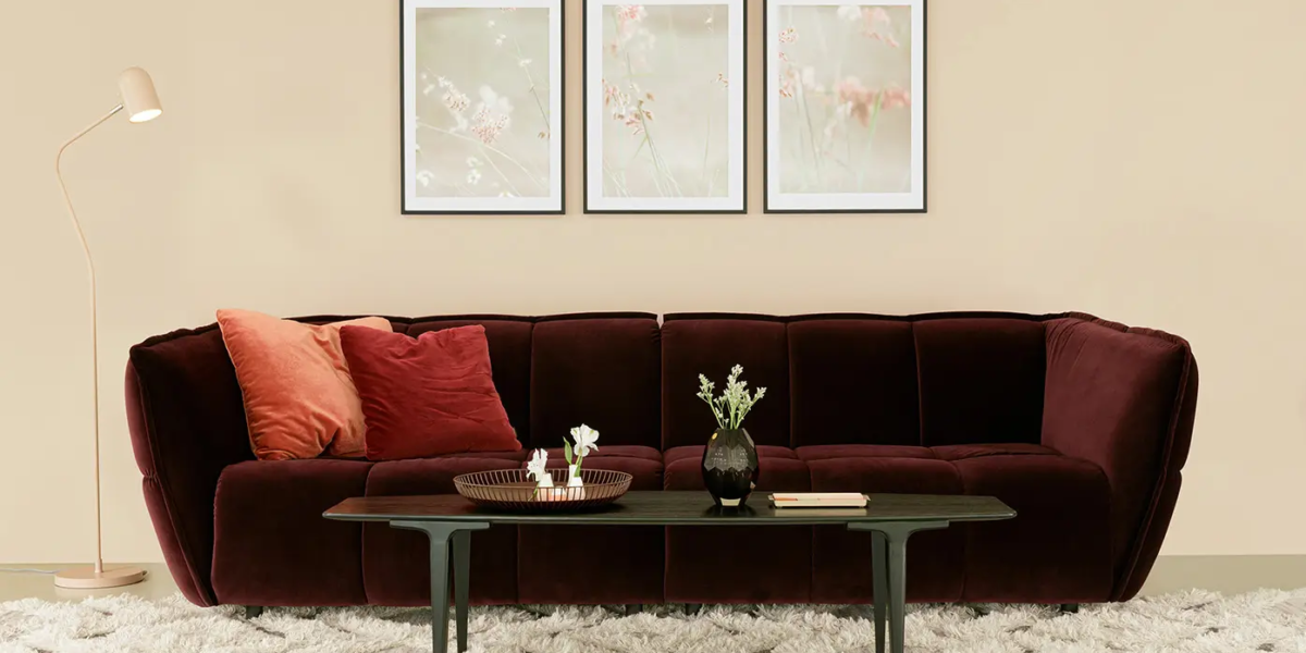 CLYDE_SITS_canape-paris_04 Une photo du canapé rose dans un décor bohème avec des tapis ethniques et des coussins aux motifs floraux pour une ambiance éclectique et chaleureuse.