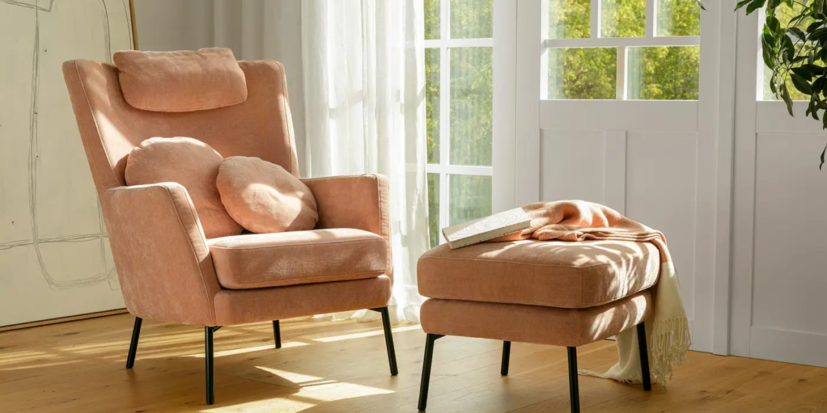 DISA_SITS_fauteuil-canape-paris_01 Fauteuil Paris en tissu rose clair avec repose-pieds assorti dans un salon lumineux.