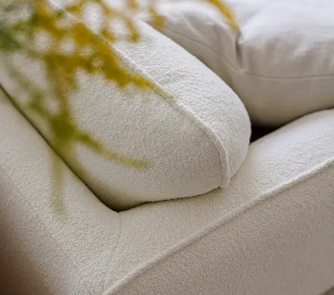 EMMA_SITS-canape-paris_04 Gros plan sur les coussins du canapé Paris, mettant en valeur la texture du tissu.